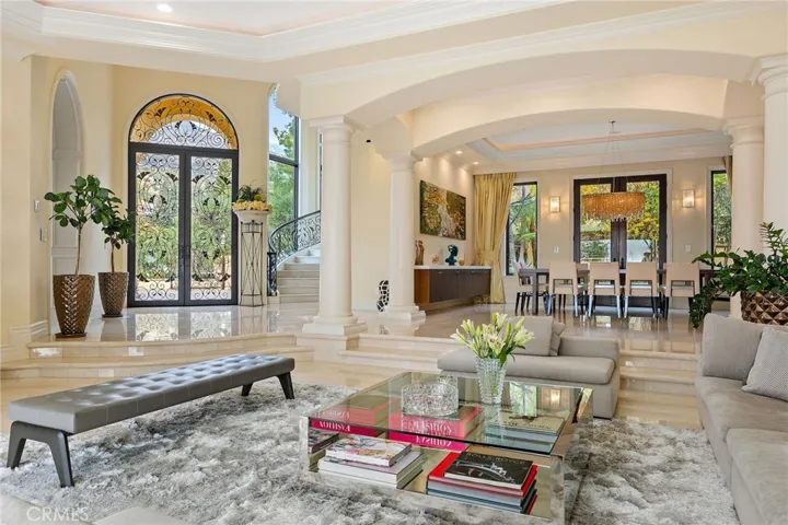 Formal dining room with a custom made table for 12-14 guests with chairs. Table is custom made and will be included in the sale. Sunken formal living room with bifold doors that open up to the patio.