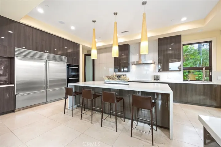 Sleek fully remodeled kitchen in 2019 with quartz countertops, a full double fridge, double ovens, and endless cabinets. Bar seating on backside of the large island.