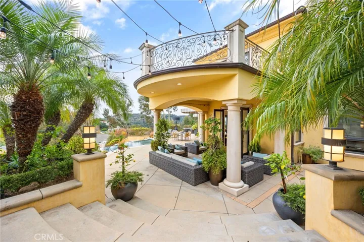 Covered patio, with stairs that lead up to the outdoor kitchen. Additionally, many fruit trees on the property.