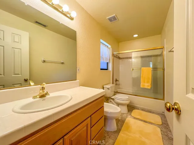 The primary bathroom has a large vanity, shower over tub and a commode and bidet.