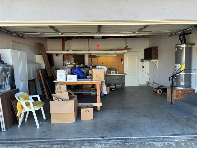Two car garage has storage cabinets, workbench, washer/dryer hookups, work bench, & opener