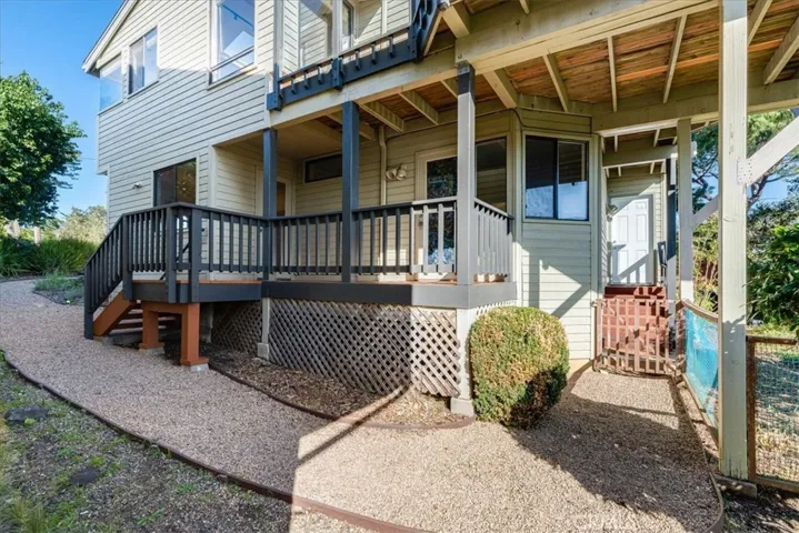 Photo from corner of property showing decks and peek of backyard.