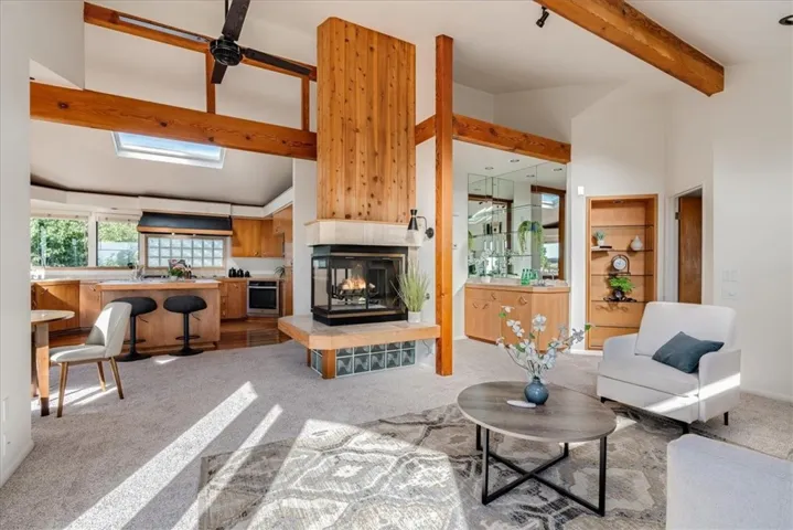View from door to deck showing living room, wet bar, fireplace, kitchen and dining area.