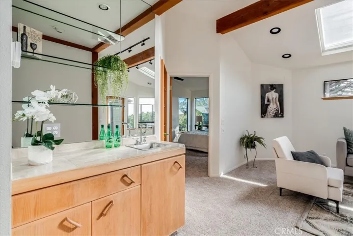 View from top of stairs looking at wet bar, living room and primary bedroom on the left of photo.