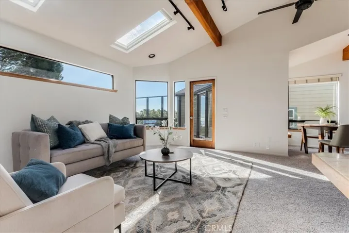 Looking at living room and door to deck and dining area on right side of photo.