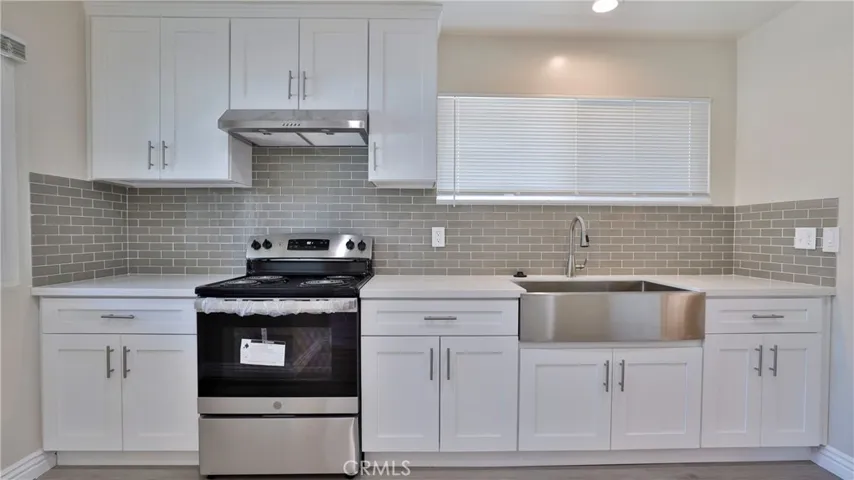 Kitchen with quart and stainless steel appliances