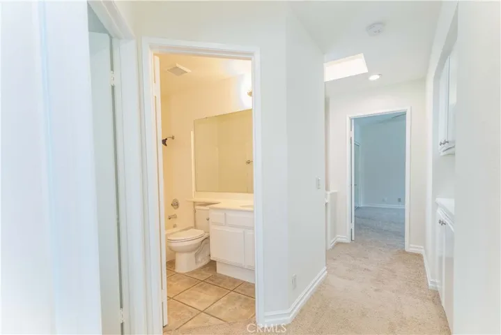 View of bathroom and hallway leading to primary bedroom.