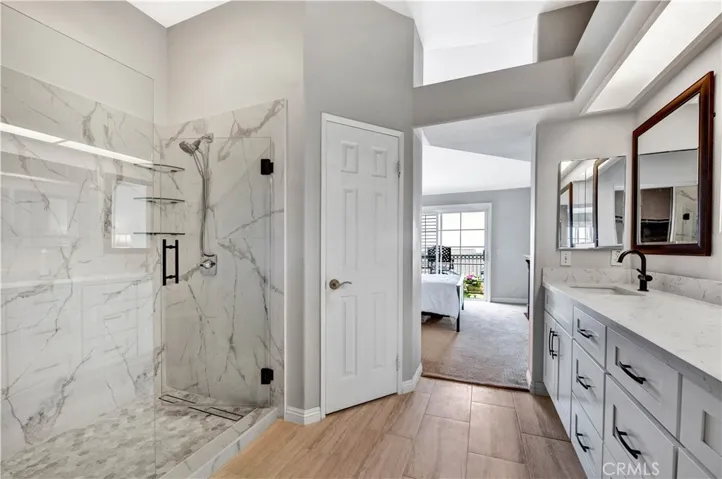Remodeled walk-in Shower with seamless glass door swings both ways