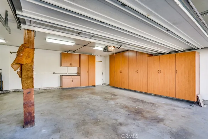 Garage has lots of storage in updated cabinets.