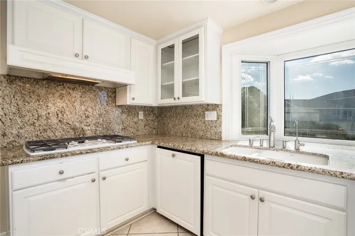 5 burner gas cooktop, granite counter tops and backsplash.