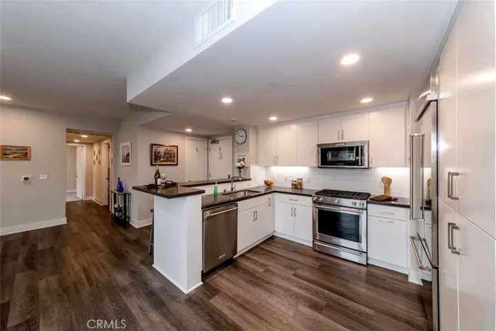 Kitchen feature stainless steel appliances, quartz counters, and built in fridge