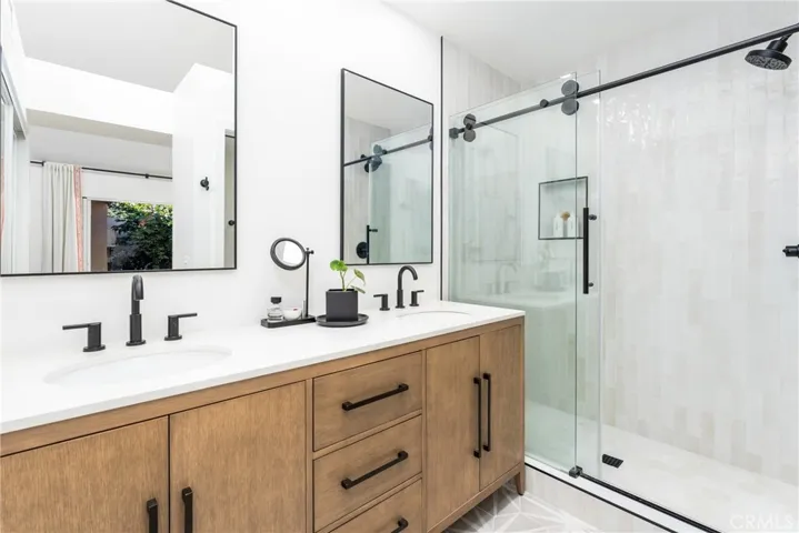 Primary en suite bathroom with dual vanity, designer finishes and separate water closet with door for the toilet.