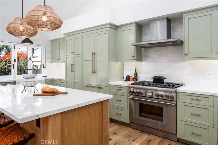 Quartz countertops, Thermador oven, a beverage refrigerator, island with microwave, full extension drawers, and upgraded cabinetry and shelving.