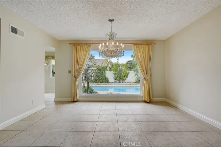 Stunning large picture window in formal dining room overlooks expansive pool