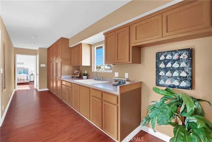 This is the Kitchenette in the Upstairs Unit. It has Tons of Cabinetry, Wood Laminate Flooring, and Recessed Lighting