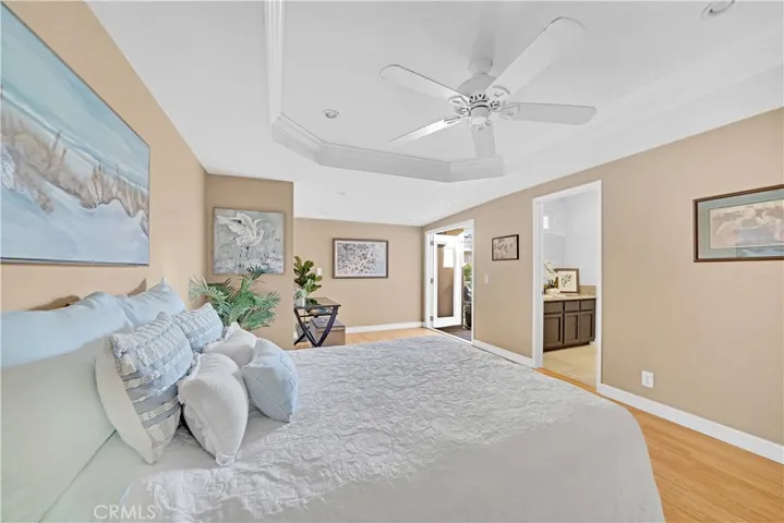 Primary Suite has Retreat Area, Coffered Ceiling, Recessed Lighting, Ceiling Fan, Wood Laminate Flooring, Mirrored Closets, French Doors w/Built-In Blinds that Open to Courtyard, and Ensuite Granite Bathroom
