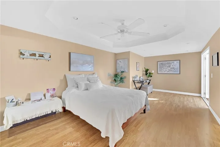 Large Downstairs Primary Suite Features Retreat Area, Coffered Ceiling, Recessed Lighting, Ceiling Fan, Wood Laminate Flooring, Mirrored Closets, French Doors w/Built-In Blinds that Open to Courtyard