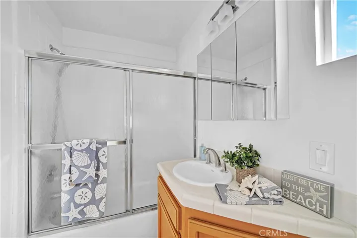 This is the Full Bathroom in the Upstairs Unit. It has a Tub/Shower Combo with Tile Walls and Glass Enclosure.