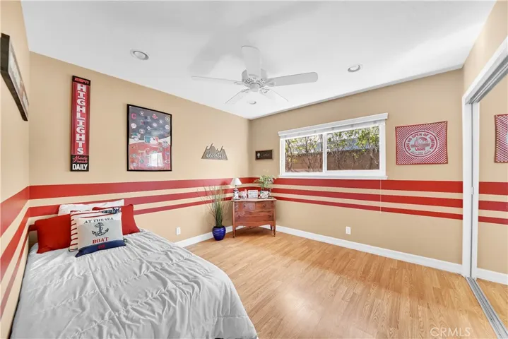 2nd Bedroom in Main House has Ceiling Fan, Recessed Lighting, Wood Laminate Flooring, and Mirrored Closet