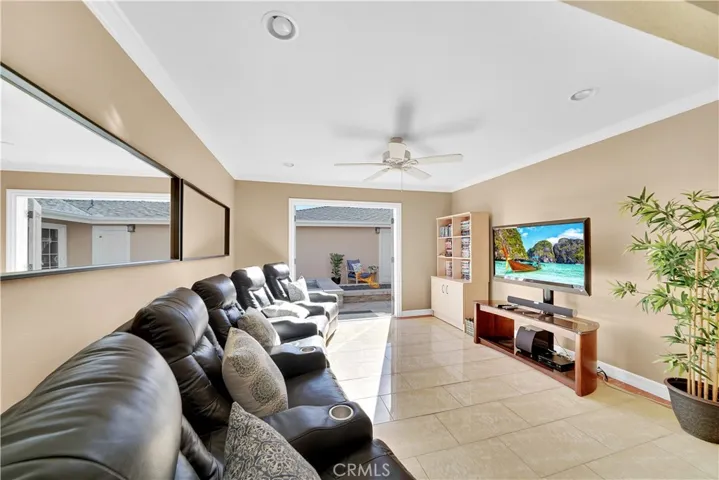 Living Room / Family Room / Movie Room with Recessed Lighting, Crown Molding, Ceiling Fan, Marble-Type Tile Flooring and French Doors with Built-In Blinds that Open to the Atrium Courtyard