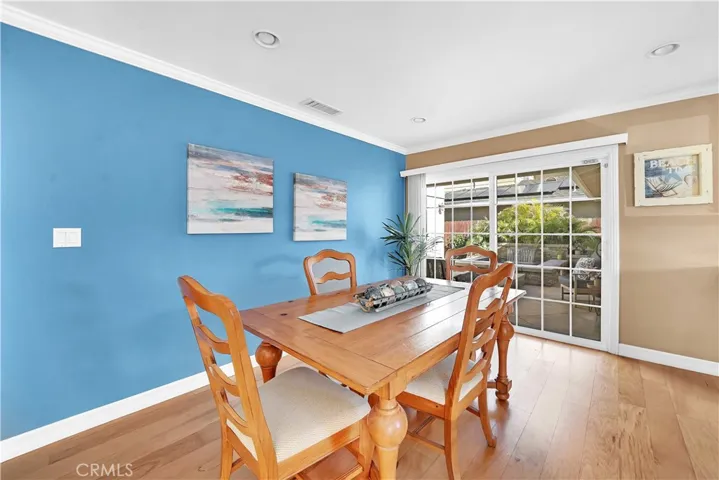 Dining Room Boasts Crown Molding, Recessed Lighting, High Baseboards, Hardwood Flooring, and French Sliders that Open to the Tropical Paradise Atrium courtyard with Spa, Water Features, and Gas Fire Ring