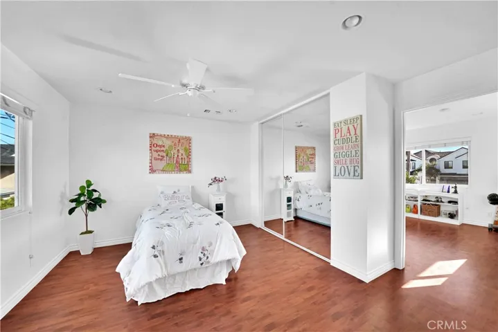 Bedroom #2 in the Upstairs Unit. It has Wood Laminate Flooring, Recessed Lighting, Ceiling Fan, Mirrored Closet, and Dual Pane Window. It has a Passage to the Dance Studio/Gym or it could be an Office or even a 7th Bedroom