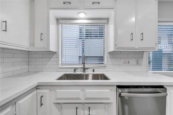 Noth view of kitchen with new kitchen fucet, dishwasher sink and shades.