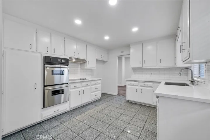West view of kitchen newly installed recessed lights toward dining room.
