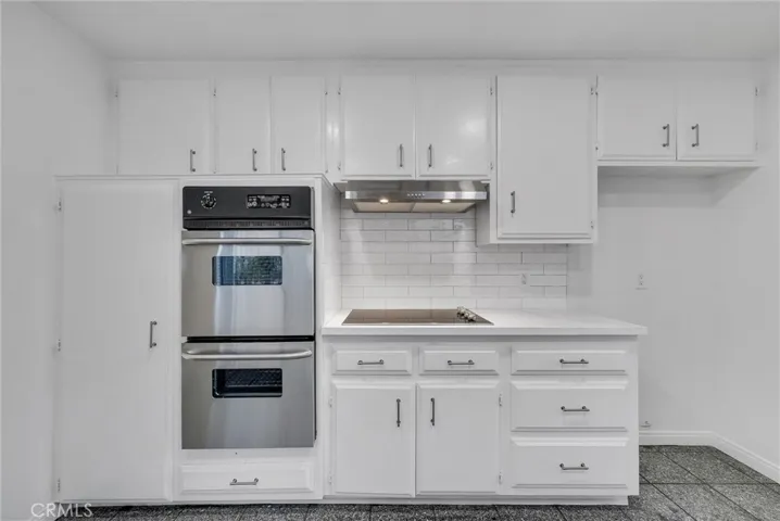 South view of kitchen with new double oven, hood and cooktop.