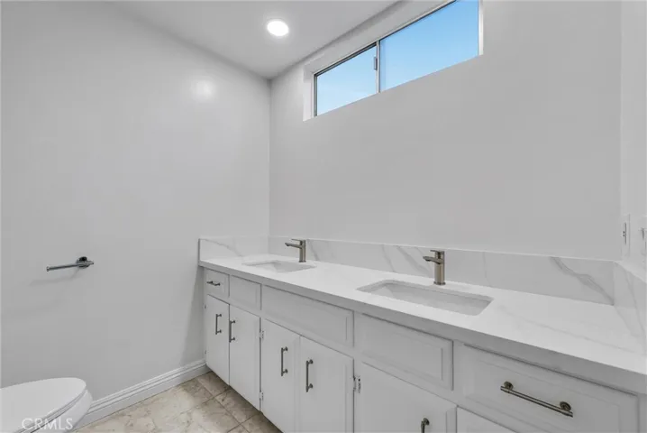 Master bathroom with newly installed quartz countertop and double sink, new faucets.