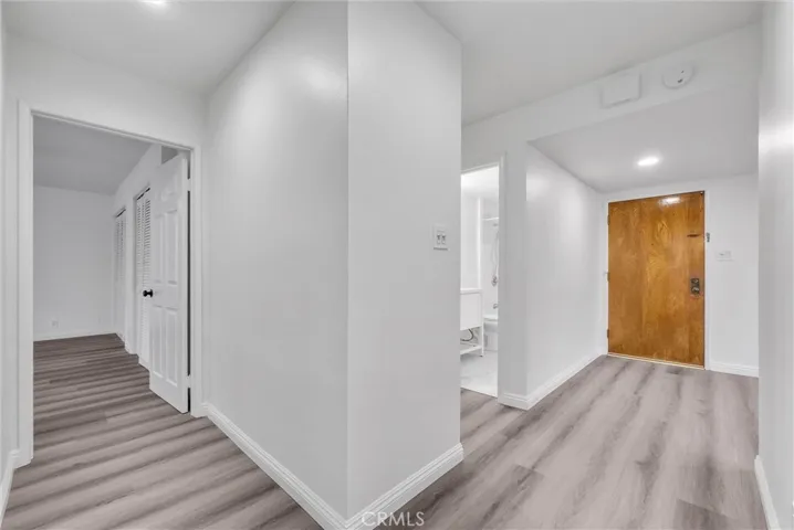 View of hallway to the entrance door, guest bathroom and master bedroom.