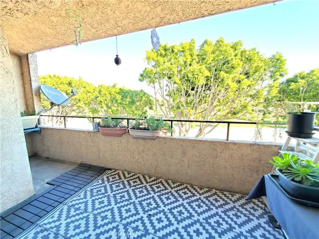 Large balcony off of living room with treetop and park view.