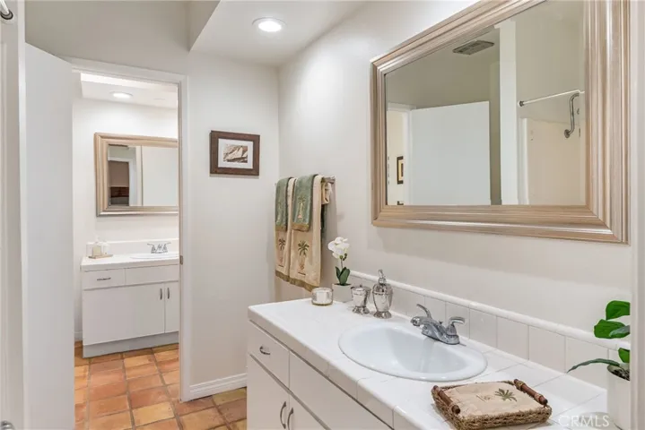 Upstairs bathroom featuring separate tub and shower, separate vanity areas, new paint, new mirrors and lighting, saltillo tile and more.