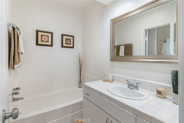 Upstairs bathroom featuring separate tub and shower, separate vanity areas, new paint, new mirrors and lighting, saltillo tile and more.
