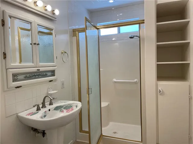 Primary suite bathroom with walk in shower and linen