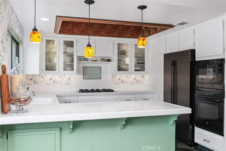 Custom lighting in the cabinets and under the counter. Pendant lights are handblown glass. The built in microwave is a nice add as well.