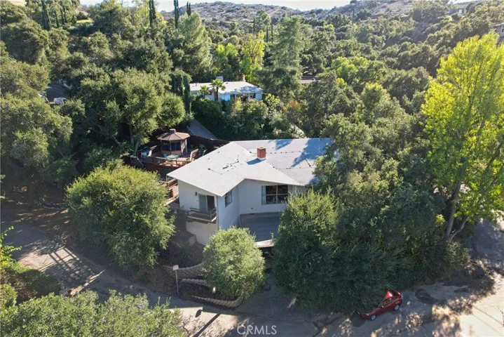 Front of house nestled among trees.