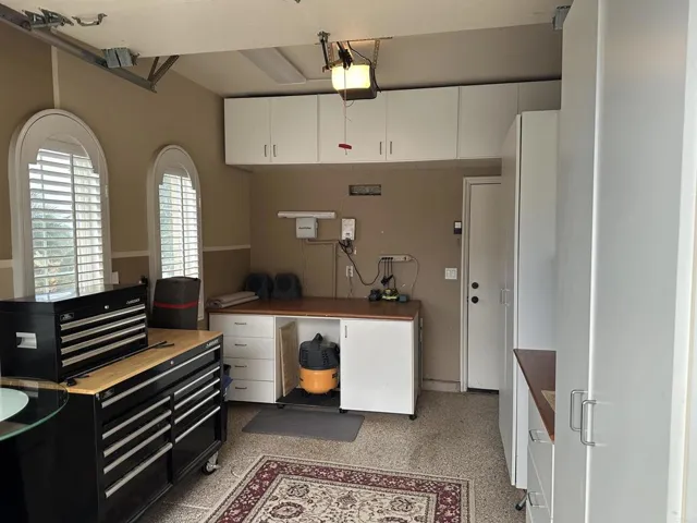 single garage (separate from 2 car garage) with built in cabinets and a large movable workbench
