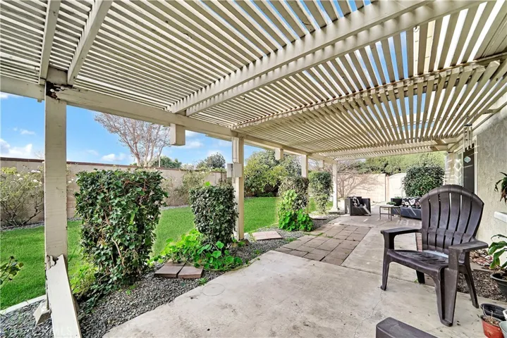 The backyard is perfect for dining and entertaining, surrounded by a block wall for added privacy and a vast grassy area for play.