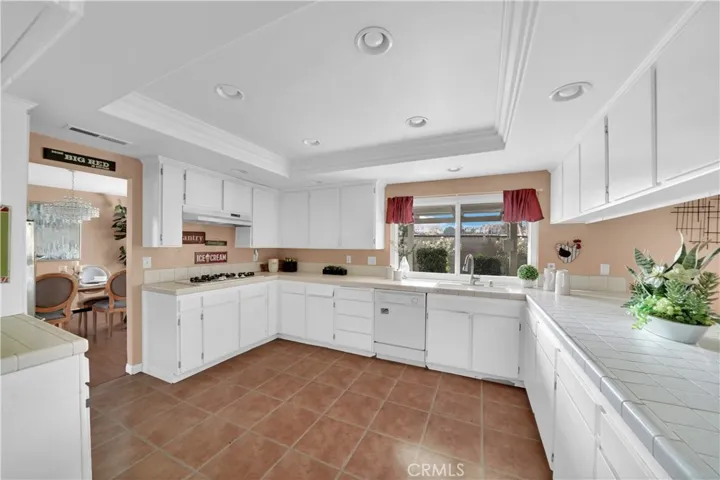 The expansive kitchen offers ample space for multiple cooks, perfect for holiday gatherings. Recessed lighting, a trey ceiling, and generous counter space.