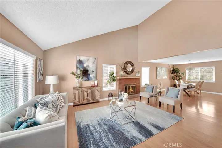 The vaulted ceilings and laminate flooring are complemented by a cozy fireplace in the living room.
