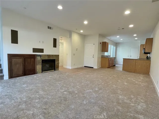 spacious living room with cozy fireplace and brand new carpet!