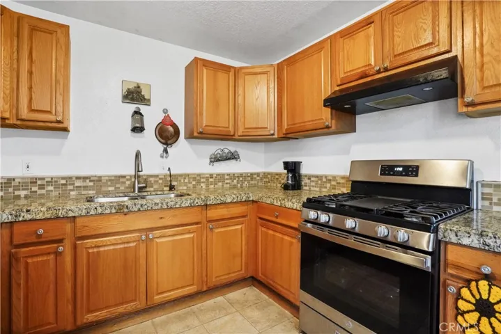 Spacious kitchen with lots of wood cabinets & lots of granite countertops