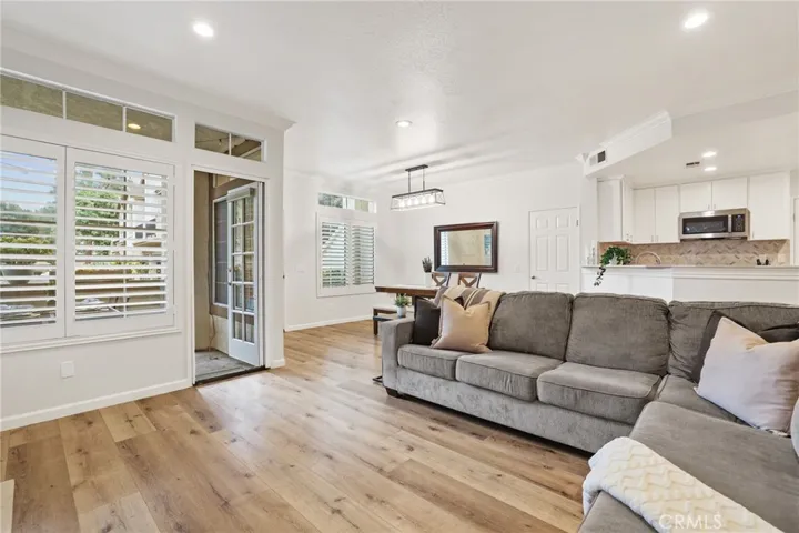 The living room with french door access to the patio and dining room on the left and kitchen on the right.