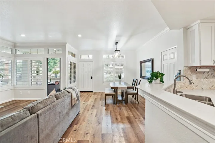 The living room on the left, entry door and dining room with kitchen on the right.
