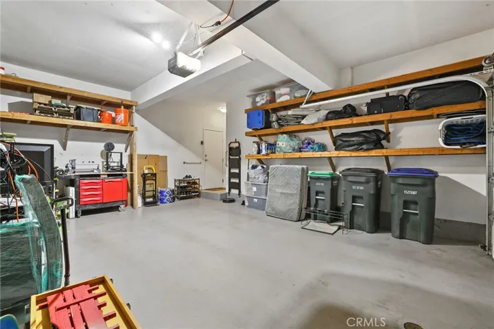 The two car attached garage features plenty of storage shelves, pegboard and a drop down table/workbench.