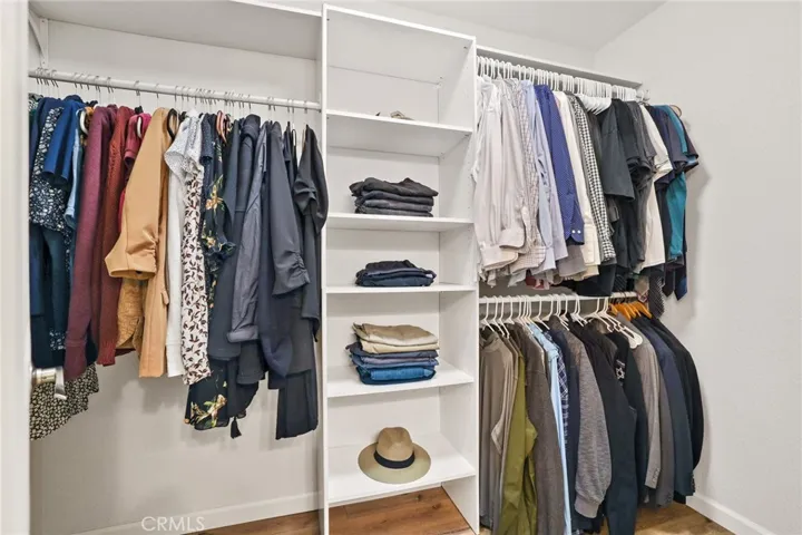 The master bath also features a walk in closet with a vinyl plank floor, closet organizers and light.