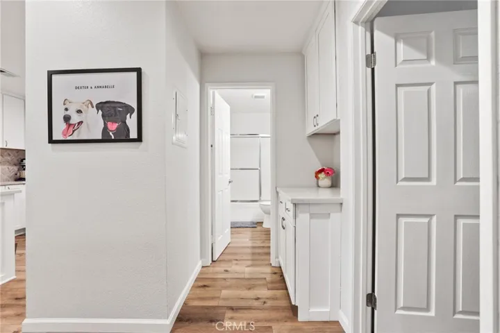 There is a quartz counter with white cabinets between the secondary bath and entry to the master bedroom.