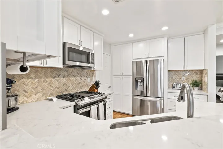 Another view of this lovely kitchen which also features recessed lights and vinyl plank flooring.