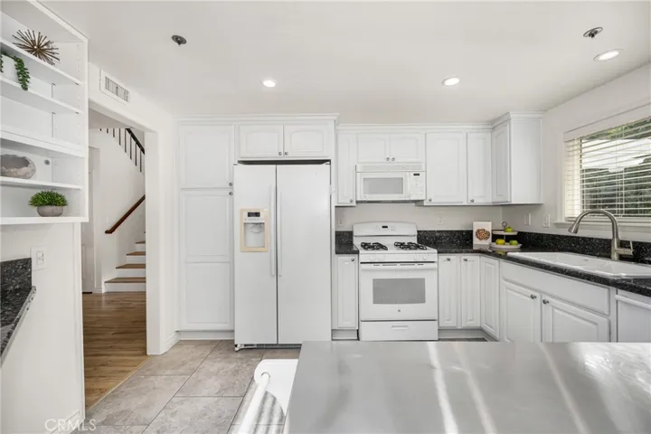 The kitchen offers lots of storage and a mobile island with stainless steel top.